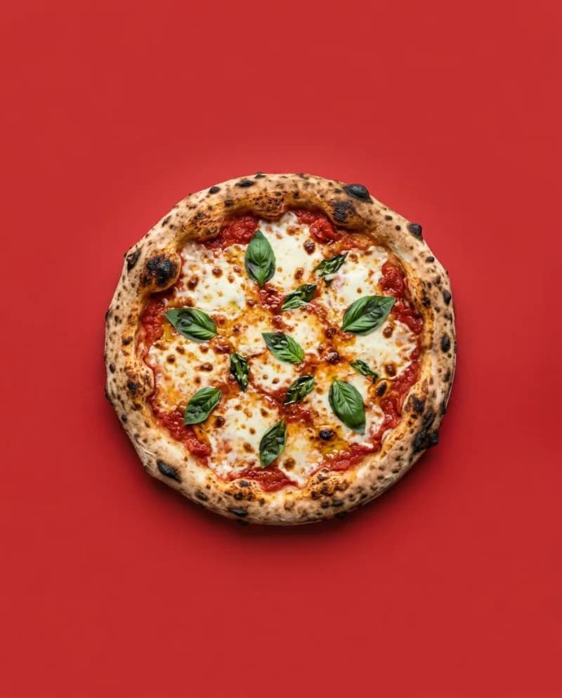 Napolitaanse pizza margherita met basilicum op een rode achtergrond, van bovenaf gefotografeerd
